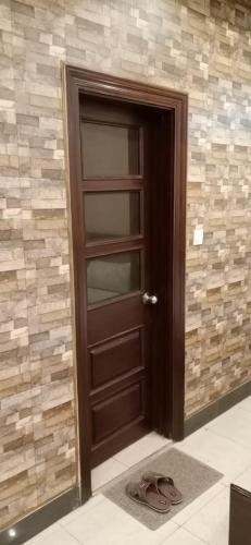 una puerta de madera en una habitación con una pared de piedra en Madina Hotel, en Faisalabad
