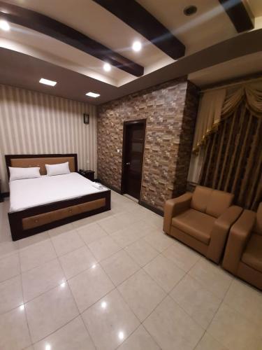 a bedroom with a bed and couch in a room at Madina Hotel in Faisalabad