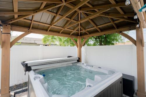 a hot tub under a wooden gazebo at Updated Family Friendly Hillyard Gem NEW HOT TUB! in Spokane