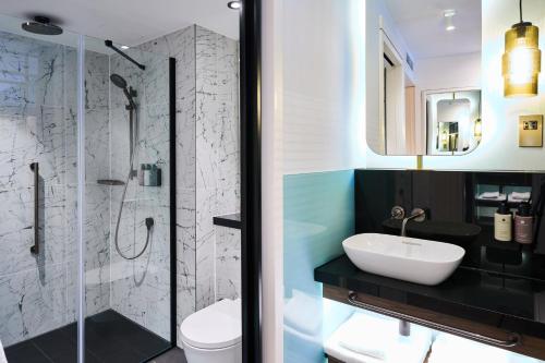 een badkamer met een glazen douche en een wastafel bij The Halyard Liverpool, Vignette Collection, an IHG Hotel in Liverpool