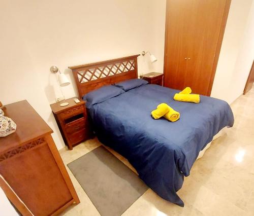 Un dormitorio con una cama con dos zapatos amarillos. en Awesome central house with 3 bedrooms, en Ceuta