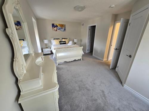 Habitación blanca con cama y espejo en Luxury corner house, en Milton