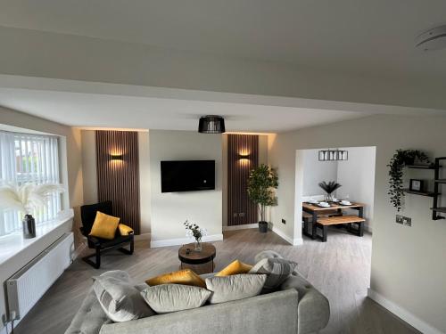 a living room with a couch and a table at The perfect place 3 Bedroom house with garden and parking in Barnsley