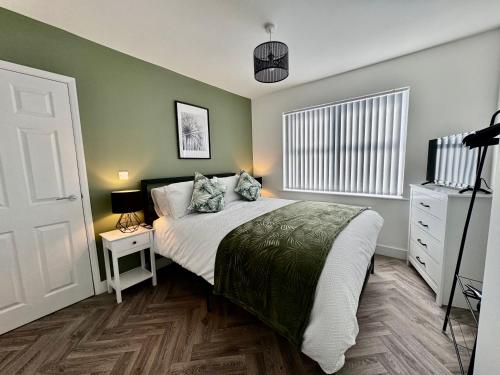 um quarto com uma cama grande e uma cómoda branca em The perfect place em Barnsley