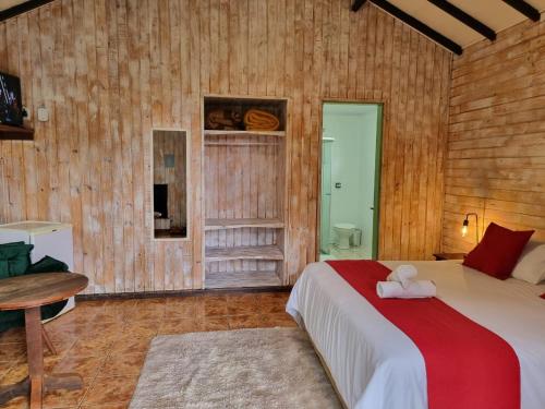 a bedroom with a bed with a towel on it at Pousada Brisa da Mantiqueira in Monte Verde