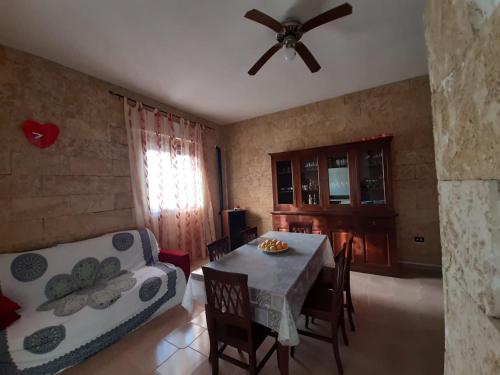 een woonkamer met een tafel en een plafondventilator bij Casa vacanza Luana torrelapillo Salento in Porto Cesareo