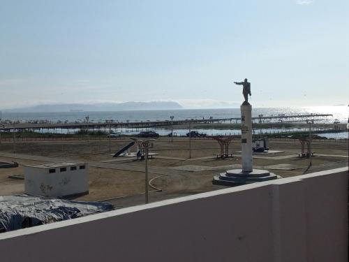 una estatua de un hombre en la parte superior de un edificio con la playa en Hospedaje Pariwana, en Pisco