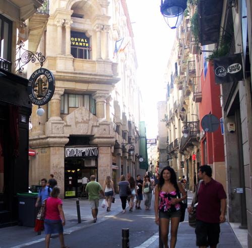a group of people walking down a street with buildings at Hostal Levante Barcelona in Barcelona