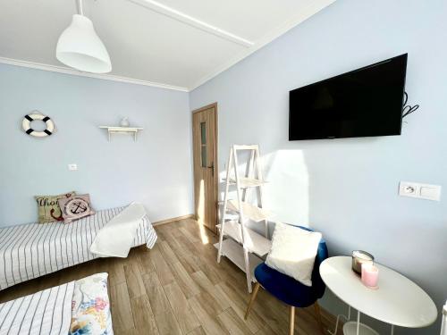 ムジェジノにあるOazaのベッド1台、壁掛けテレビが備わる小さな客室です。