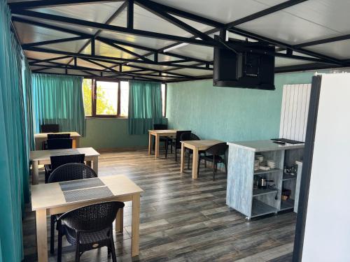 una sala da pranzo con tavoli, sedie e pareti verdi di West Star Hotel a Kutaisi