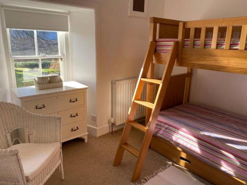 une chambre avec un lit superposé et un bureau dans l'établissement Christmas Cottage, à Balmaha