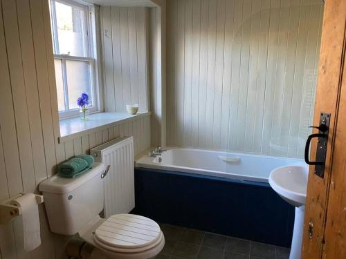 une salle de bain avec toilettes, baignoire et lavabo dans l'établissement Christmas Cottage, à Balmaha