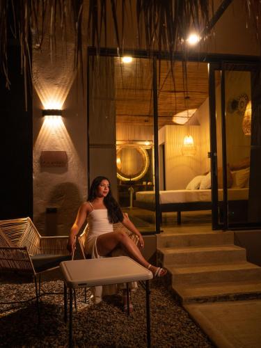 a woman sitting on a bench in a room at Jungla EcoLuxury Resort in Villeta