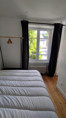 une chambre avec un lit et une grande fenêtre dans l'établissement Appartement 1 Maison Dior, centre, plage à 500 m, à Granville