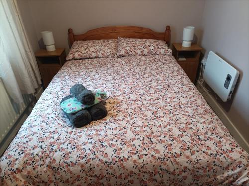 uma cama com um urso de peluche em cima em The Croft Apartment em Westport