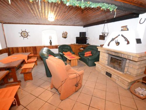 a restaurant with a fireplace and couches and tables at Chalet in Ore Mountains near Ski Slopes in Jindřichovice