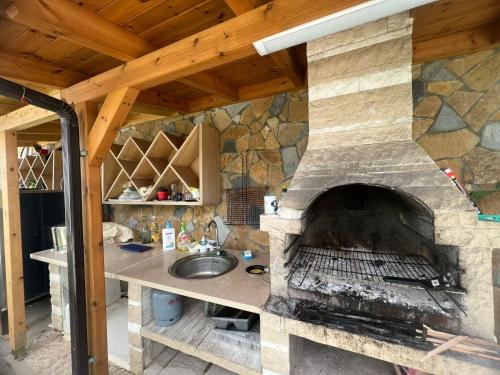 a kitchen with a stone oven with a sink at Guest Room Angolo Toscano in Vlorë