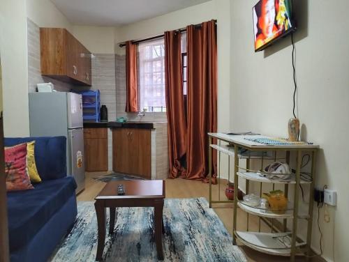een woonkamer met een blauwe bank en een tafel bij Tamara studio bedsitter, Nyanchwa Kisii in Kisii