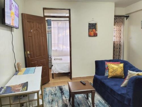 a living room with a blue couch and a table at Tamara studio bedsitter, Nyanchwa Kisii in Kisii