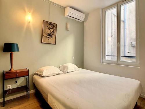 a bedroom with a large white bed and a window at LE BOBO - Vieux-Port in Marseille