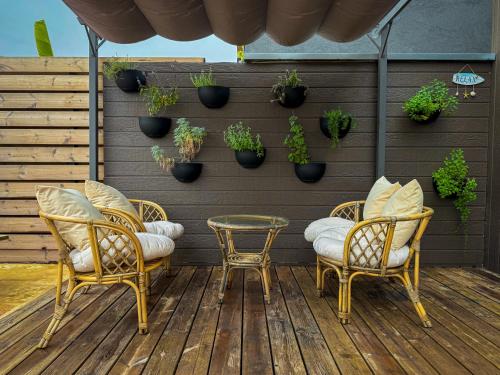 a patio with two chairs and a table and potted plants at Gilboa cliffs- Royal mountain villa in Nurit