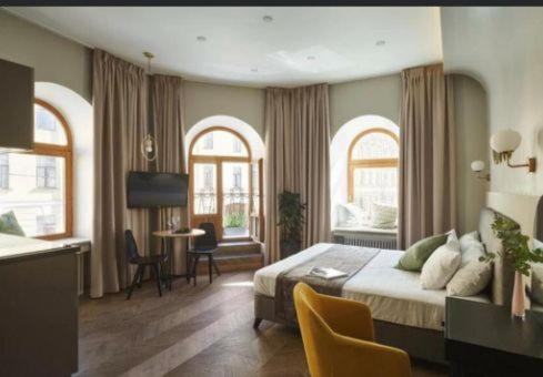 um quarto com uma cama, uma mesa e 2 janelas em Royal Sea Resort em Aktau