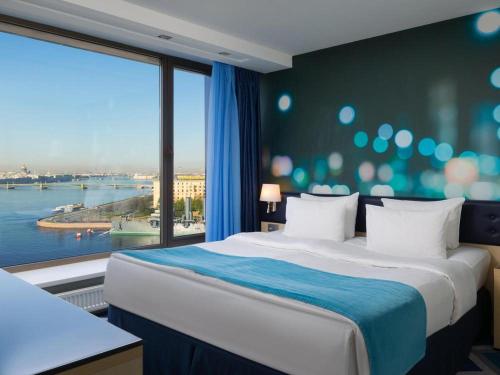 アクタウにあるRoyal Sea Resortの大きなベッドと大きな窓が備わるホテルルームです。