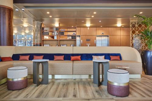 a living room with a couch and two stools at voco Paris - Porte de Clichy by IHG in Clichy