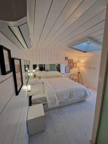 une chambre avec un grand lit blanc avec un plafond dans l'établissement Duplex 90m² + terrasse, à Bayonne