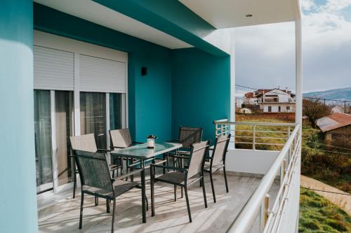 a patio with a table and chairs on a balcony at Pamvotis Urban Suites in Ioannina