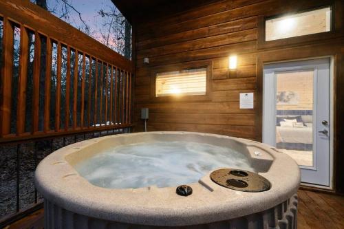 a large jacuzzi tub in a room with wooden walls at Diamond Cabin w/ jet shower & secluded back deck! in Broken Bow