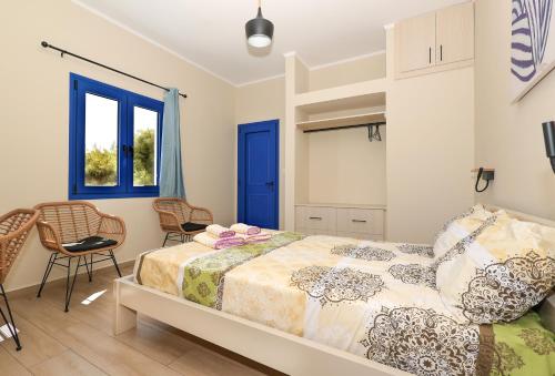a bedroom with a bed and a blue door at Niko's Beach Suites ΕΝΑ in Agia Marina Aegina