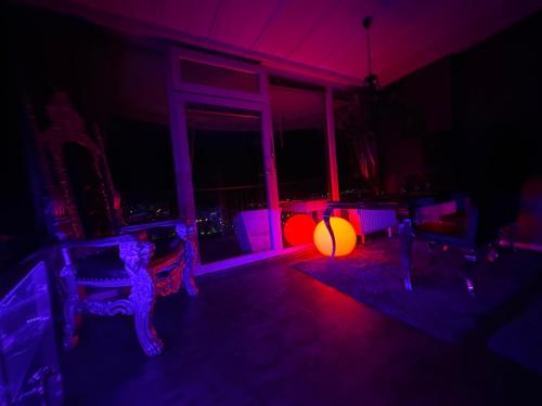 a room with purple and orange lights and chairs at Royal - Sky - Suite in Augsburg