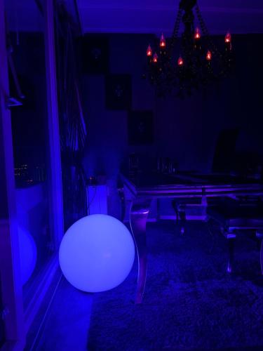 a living room with a table and a purple light at Royal - Sky - Suite in Augsburg