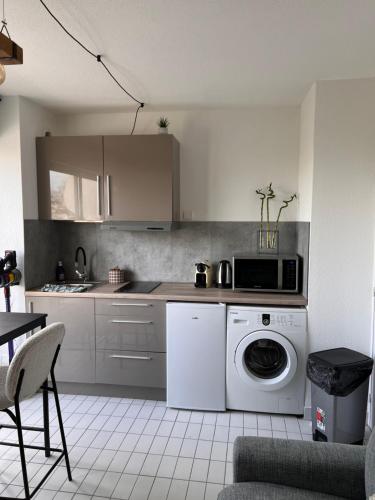 una cucina con lavatrice e microonde di Studio première ligne mer parking a La Grande-Motte