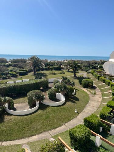 un parco con cespugli e alberi e un sentiero di Studio première ligne mer parking a La Grande-Motte