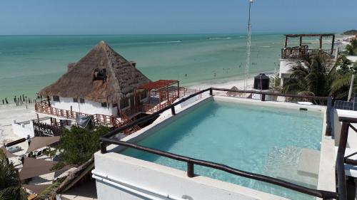 a swimming pool on top of a building next to the beach at HAU Holbox, Oceanfront Boutique Hotel in Holbox Island