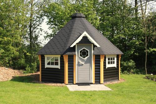 a small black shed with a black roof at Finse Kota's Schotererf in Kuinre