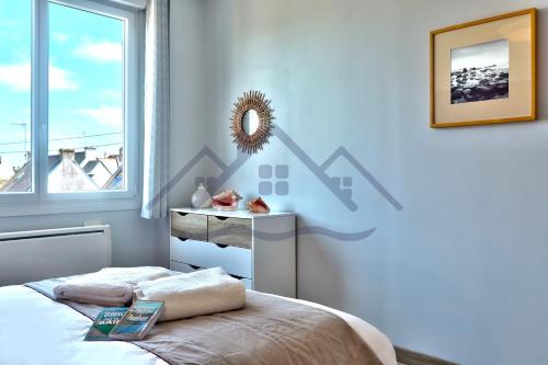 a bedroom with a bed and a mirror on the wall at LocaLise - M2C - Ty Ma Bro -Maison avec extérieur entièrement clos - Wifi inclus - Draps inclus- Animaux bienvenus in Le Guilvinec