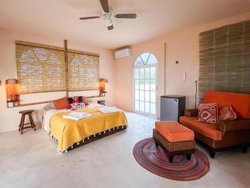 - une chambre avec un lit, un canapé et une chaise dans l'établissement La Casa del Sol, à El Cuyo