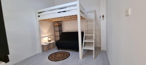 Cette petite chambre comprend des lits superposés et une chaise. dans l'établissement DUPLEX PISCINE MER, à La Rochelle