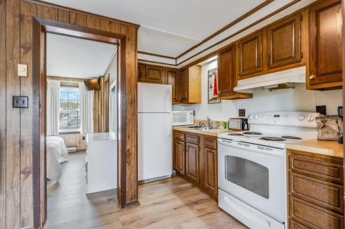 una cocina con electrodomésticos blancos y armarios de madera en The Inn at Lewes, en Rehoboth Beach