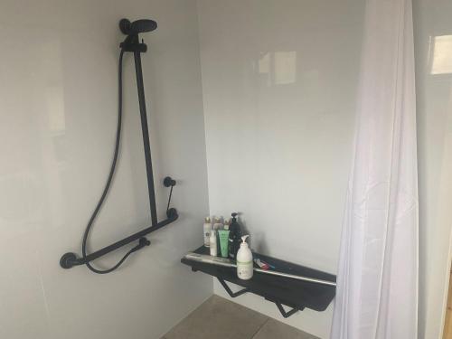 a bathroom with a black shelf on the wall at Hygge Eco Cabins Beautiful New Cabins with Amazing Views in Jindabyne
