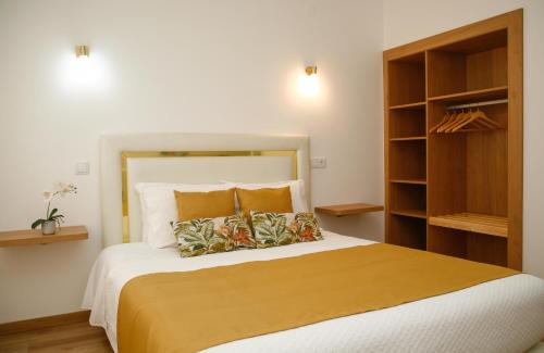 a bedroom with a large bed with two pillows at Nova Delpa AL in Caldas da Rainha