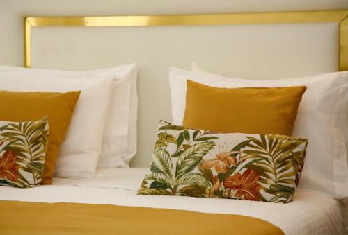 a bed with white sheets and pillows at Nova Delpa AL in Caldas da Rainha