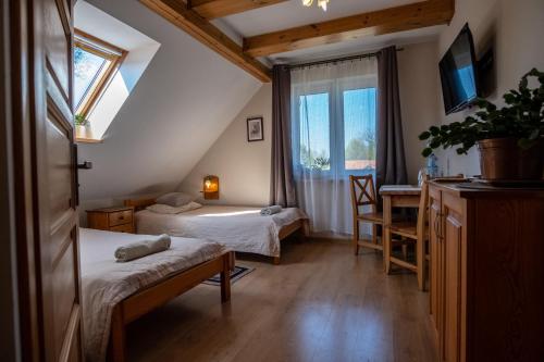 a room with two beds and a window at Siedlisko Leszczewek in Leszczewek