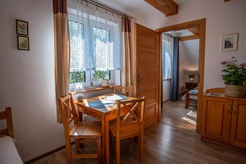 a dining room with a table and chairs and a window at Siedlisko Leszczewek in Leszczewek