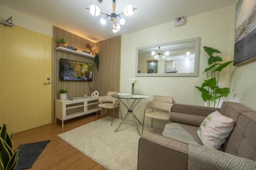 Scarlet Suites Condominium في Babak: غرفة معيشة مع أريكة وطاولة