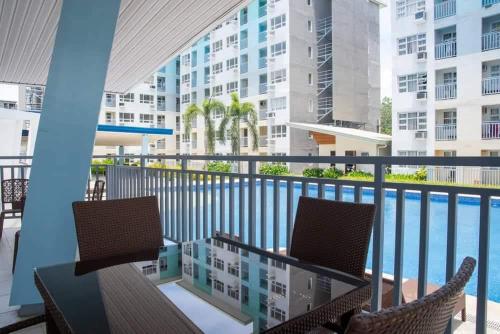 Babak的住宿－Scarlet Suites Condominium，一个带桌椅的阳台和一个游泳池