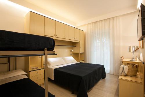 リド・ディ・イエゾロにあるHotel Grottamareのベッドルーム1室(ベッド1台、二段ベッド1組付)